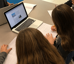 students doing school work on a laptop