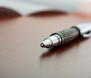 Pen and paper on a wood table